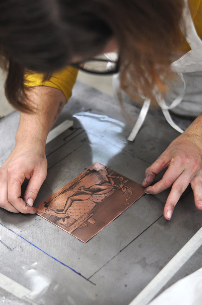 artist lining up a copper plate