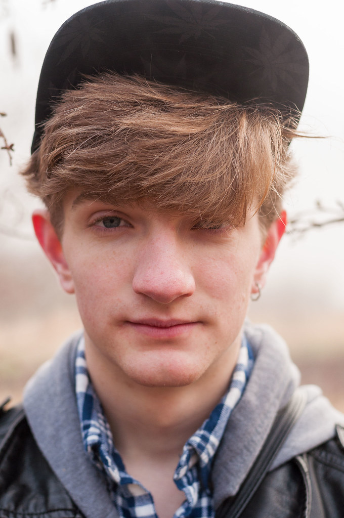 A headshot of a person in a hat