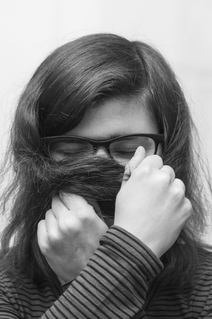 A headshot of a person hiding their face.