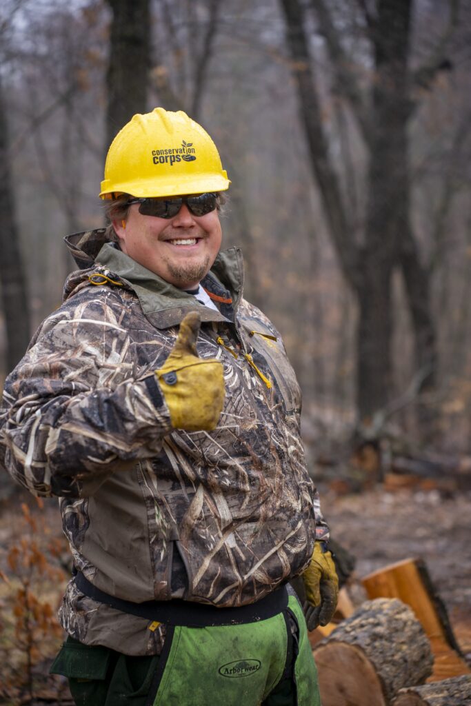 A person in a hard hat giving a thumbs up.